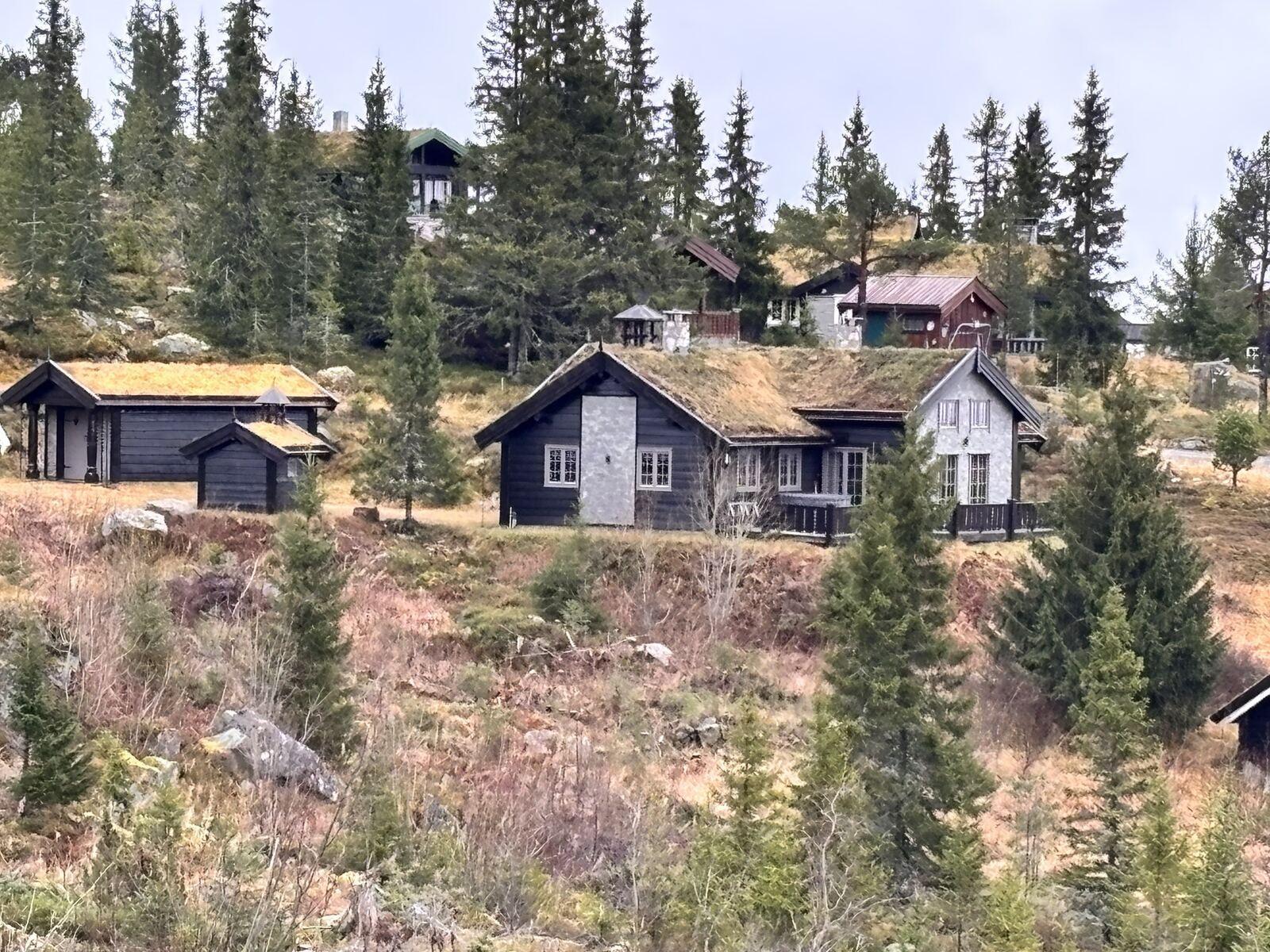Hytta og garasjen sett nedenfra om høsten